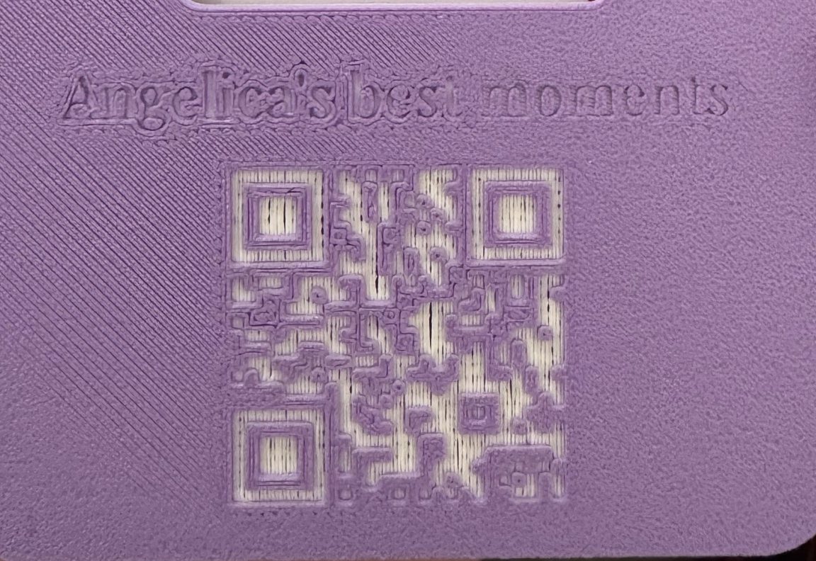 Detalle de la placa impresa: el título grabado y el QR de 25 por 25 módulos tallado como pocillos en la cara